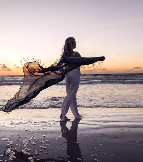 Woman walking on the beach at Sunset