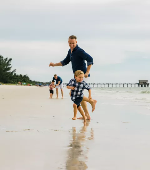 Father and son play on Naples Beach.