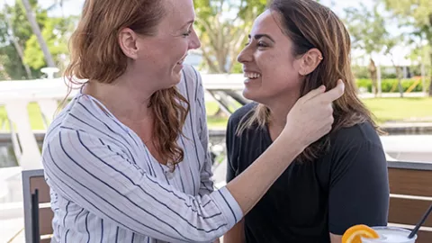 Two women eating lunch and looking at each other