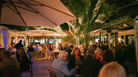 A wide view of a dining patio with many diners enj